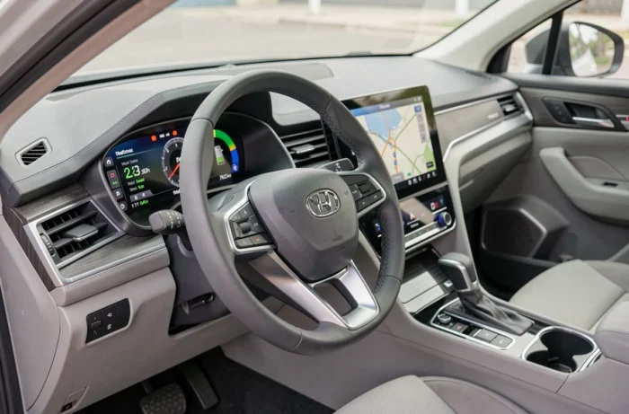 Intérieur d'un SUV hybride moderne avec tableau de bord numérique affichant la consommation en temps réel et écran tactile de navigation